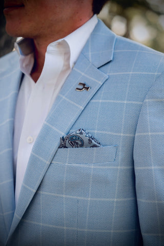 Light blue checkered suit jacket with a white shirt and patterned pocket square.