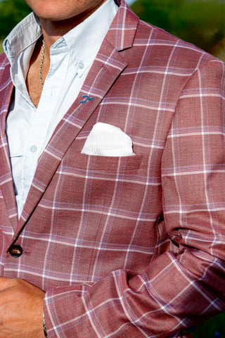 Close-up of a person wearing a red plaid blazer with a white shirt and pocket square.
