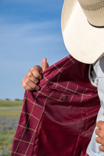 Person wearing a red plaid shirt with a blurred natural background