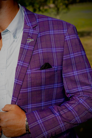 Purple checkered blazer worn by a person with a blurred green background