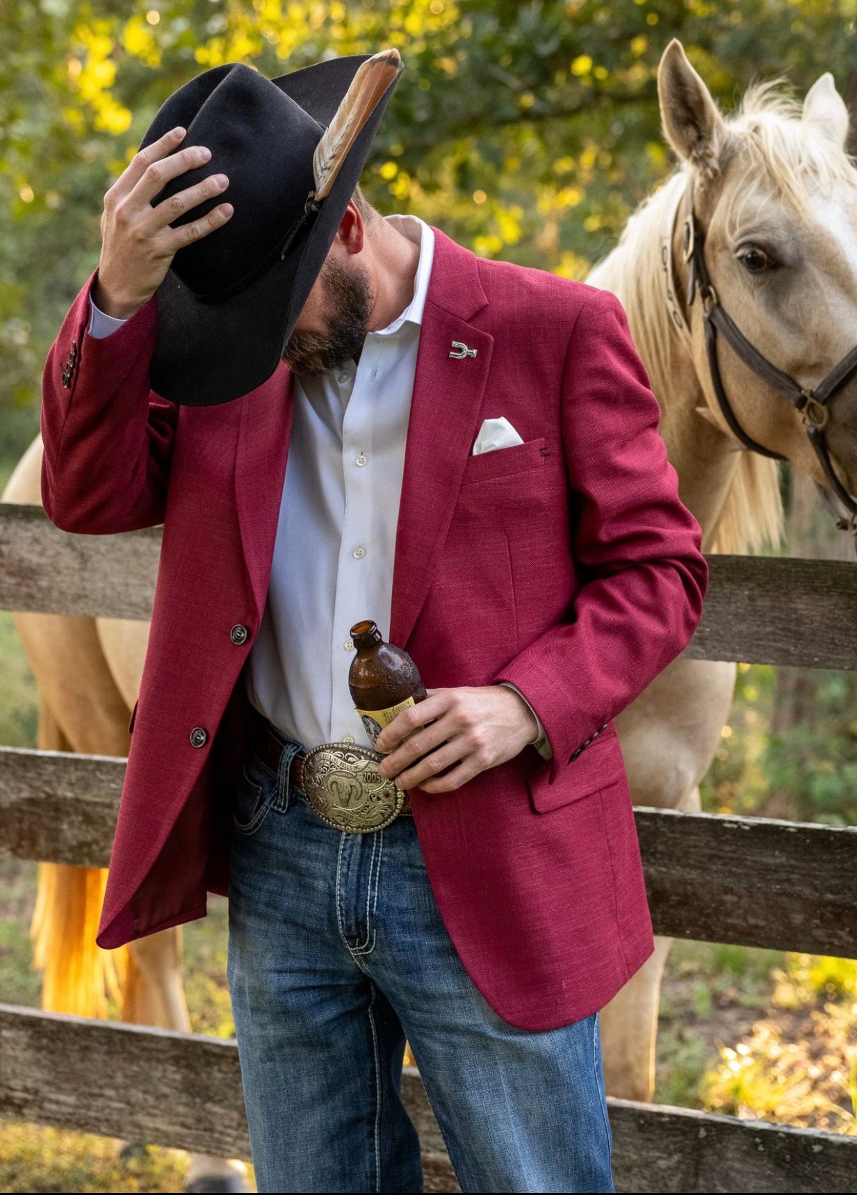 Man in a red blazer with a horse in the background