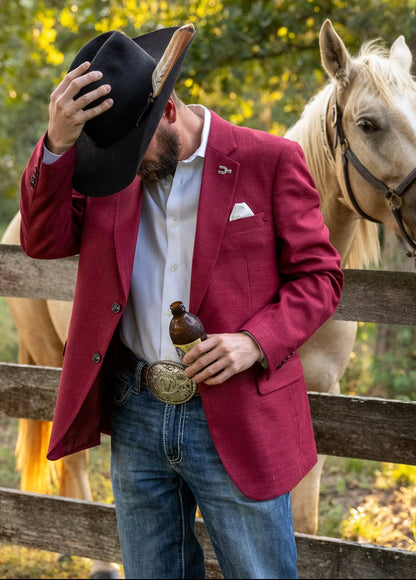 Man in a red blazer with a horse in the background
