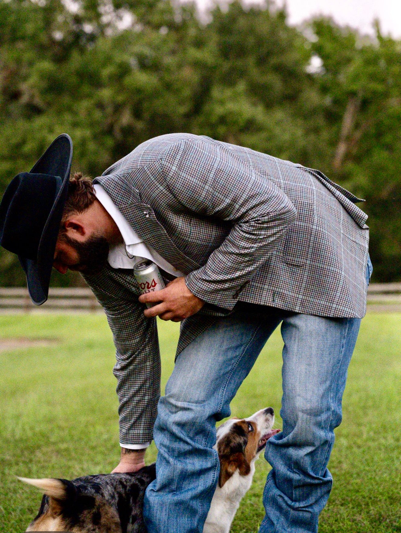 Model wearing turquoise grey brown plaid cowboy sport coat with jeans and boots