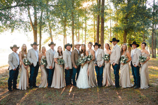 Group of people in formal attire with cowboy hats standing in a forest. Western wedding styled with cowboy hats, boots, and jeans. Cowboy sport coat style. Western Wedding Jackets.